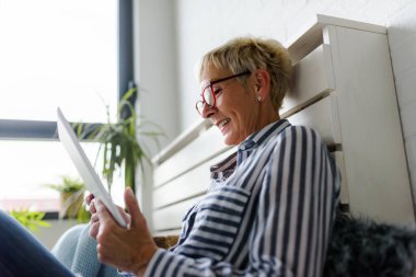 Güzel Olgun kadın evde tablet kullanma
