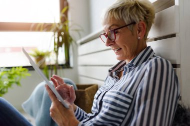 Güzel Olgun kadın evde tablet kullanma