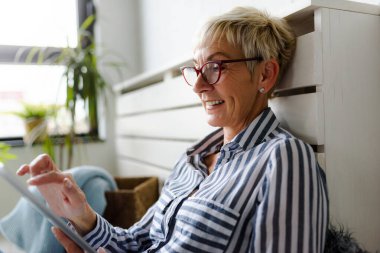 Güzel Olgun kadın evde tablet kullanma