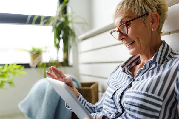 stock image beautiful mature woman using tablet at home