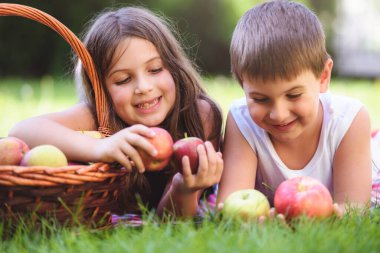 Abi ve kız kardeş elma dolu sepetle poz veriyorlar.