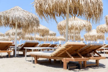 Tropik sahil beldesinde güneşlik ve şemsiyeler