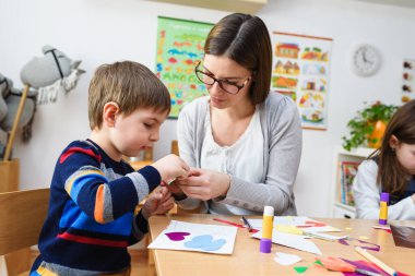 Anne ve çocuklar birlikte zanaat yaparak vakit geçiriyorlar. 