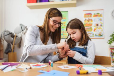 Anne ve çocuk birlikte ev ödevi yapıyorlar. 