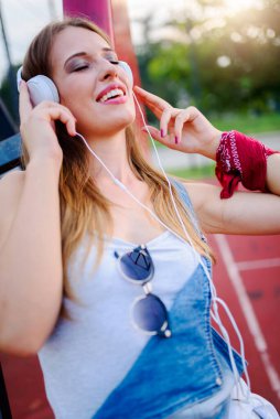 Kulaklıkla müzik dinleyen genç bir kadın.