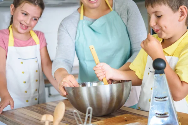 stock image mother, daughter and son cooking pastry together, working with dough