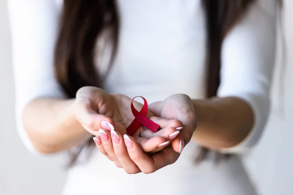 woman holding red ribbon with aids awareness symbol