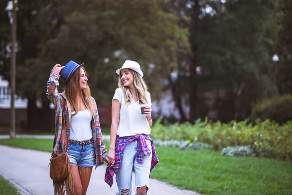 两个年轻女子在绿地里散步 女学生在说话好朋友 — 图库照片