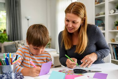 Gururlu anne çocuğuna evde nasıl yazacağını öğretiyor. Erken eğitim