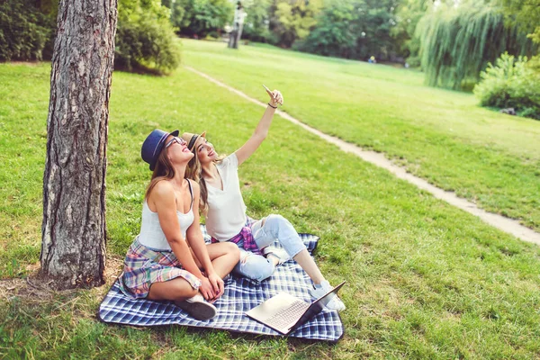 女の子の友人の公園で毛布を携帯電話で写真を撮るに座っている セルフィー — ストック写真