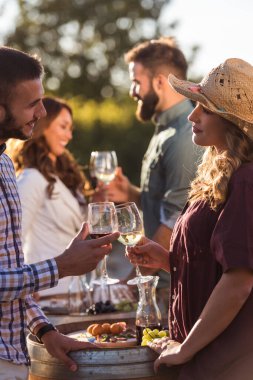 Arkadaşlar şarap içip üzüm bağında piknik yapıyorlar.