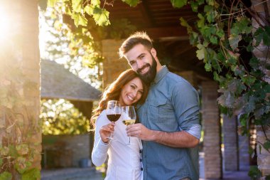 Genç çift üzüm bağında şarap içiyor. 