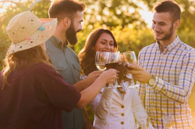 Arkadaşlar şarap içip üzüm bağında piknik yapıyorlar.