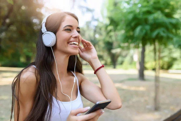 Mujer Sonriente Escuchando Música Sentado Banco Parque — Foto de Stock