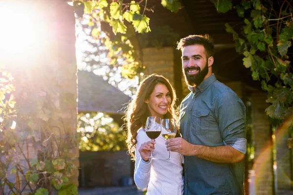 年轻夫妇在葡萄园里喝酒 — 图库照片