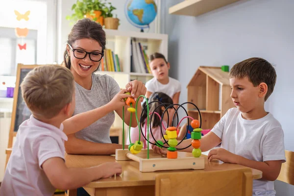 Anaokulunda Renkli Ahşap Oyuncaklarla Oynayan Çocuklu Anaokulu Öğretmeni — Stok fotoğraf