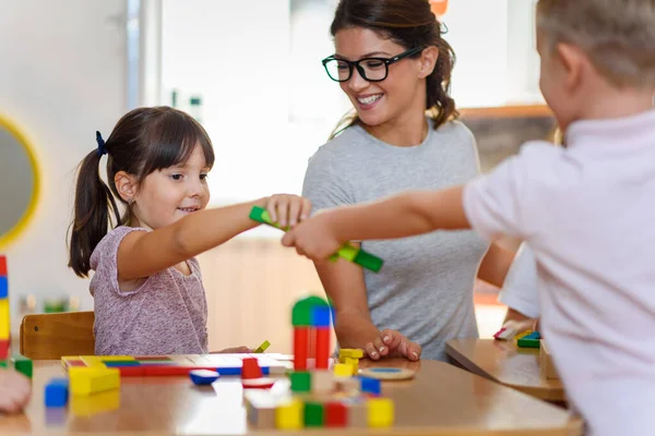 Erzieherin Mit Kindern Beim Spielen Mit Bunten Holzspielzeugen Kindergarten — Stockfoto