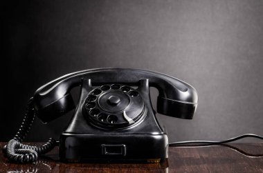 Ahşap masada eski model bir telefon. 