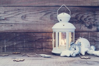 Ahşap arka planda yanan bir mum bulunan klasik bir fener.