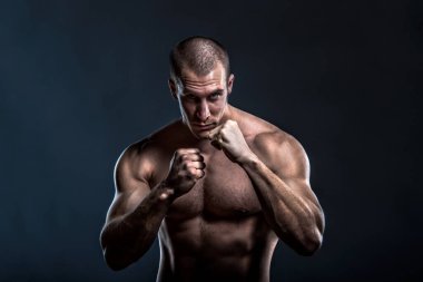 Siyah arka planda çıplak vücut pozu veren yakışıklı kaslı adam. 