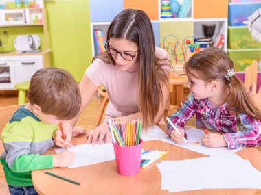 Anaokulunda resim yapan şirin çocuklar. 