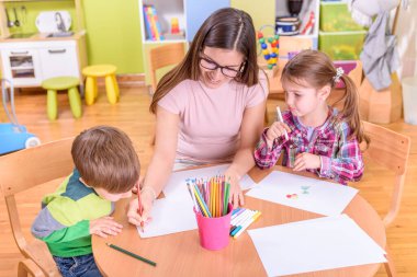 Anaokulunda resim yapan şirin çocuklar. 