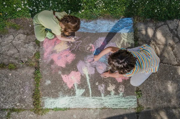 孩子们在人行道上用粉笔画画 — 图库照片