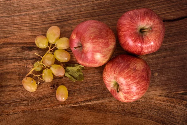 木の上のリンゴとブドウ Rustic Table — ストック写真