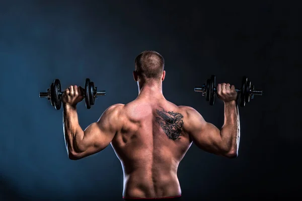 Muskulöser Mann Mit Hanteln Auf Schwarzem Hintergrund — Stockfoto