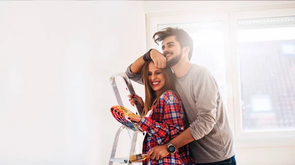 Junges Paar Wählt Farbe Für Das Malen Nach Hause — Stockfoto