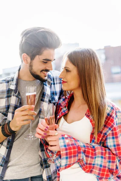 年轻的休闲夫妇在公寓平台上喝香槟庆祝 — 图库照片