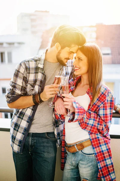 年轻的休闲夫妇在公寓平台上喝香槟庆祝 — 图库照片