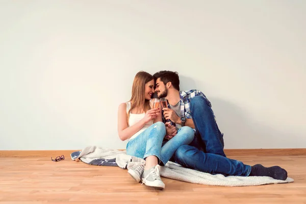 Junges Paar Sitzt Auf Dem Boden Leerer Wohnung Und Feiert — Stockfoto