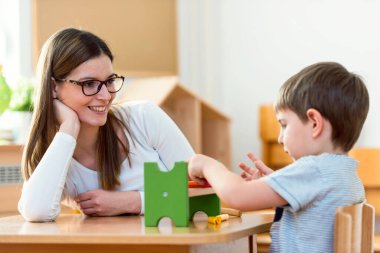 Anaokulunda birlikte oynayan mutlu öğretmen ve öğrenci.
