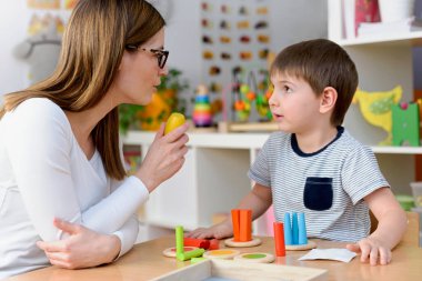 Anaokulunda birlikte oynayan mutlu öğretmen ve öğrenci.