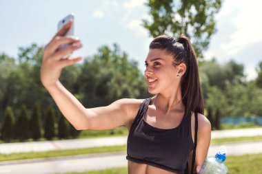Genç ve güzel bir kadın akıllı telefonuyla selfie çekiyor. 