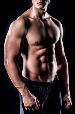 Siyah arka planda poz veren yakışıklı bir adam.