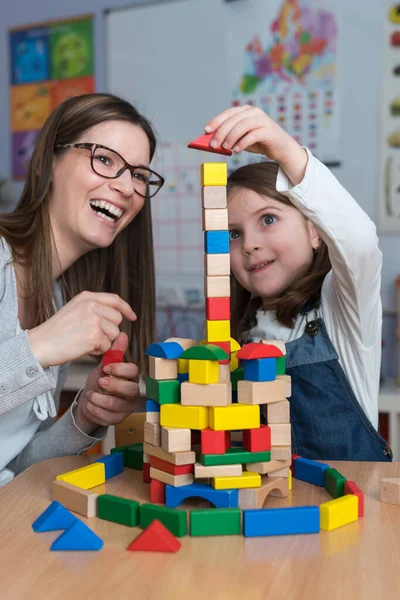 Glad Lärare Och Barn Leker Med Leksaksblock Hemma — Stockfoto