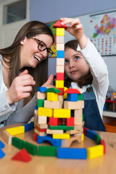 Glad Lärare Och Barn Leker Med Leksaksblock Hemma — Stockfoto