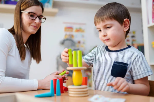 stock image Proud mother looking at her son playing didactic games learning