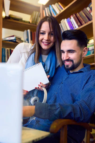 図書館でノートパソコンを扱う学生カップル — ストック写真