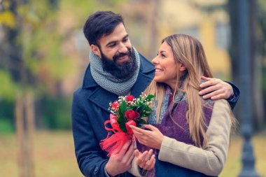 Gülümseyen Romantik Sevgililer Günü Çifti Parkta Çiçeklerle