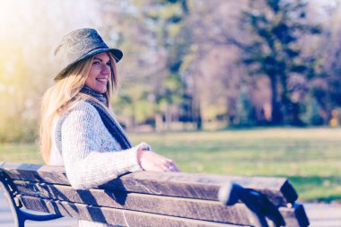 Bankta oturan güzel sarışın kız.