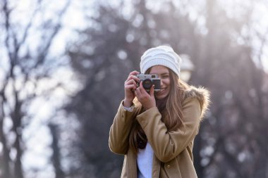 Eski model fotoğraf makinesiyle fotoğraf çeken bir kızın portresi.