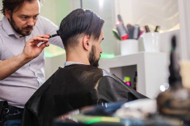 Kuaförde saçını kestiren bir adam.