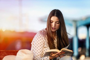 Tren istasyonunda kitap okuyan güzel bir kız. 