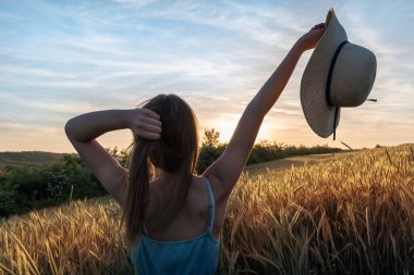 Buğday tarlasında güzel genç bir kadın.