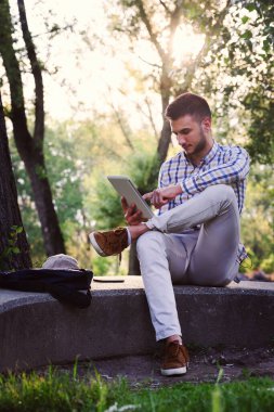 Ekose takım elbiseli, tablet kullanan sıradan bir genç.