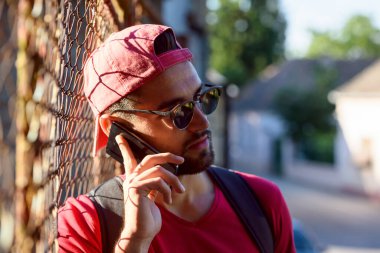 Genç şehirli hippi gezgin telefon görüşmesi yapıyor.