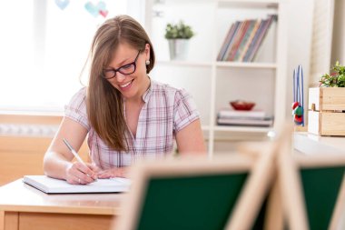 Sınıfta notlar yazan genç bir kadın.